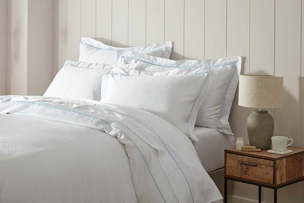 Luxuriously soft organic cotton flat sheet in white with color trim.
